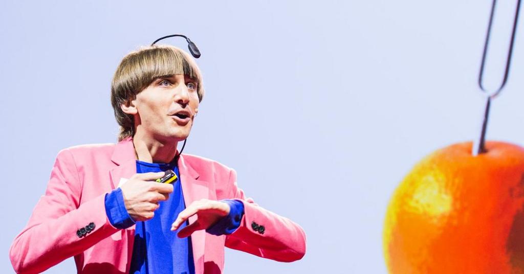 An image of Neil Harbisson giving a TED talk.